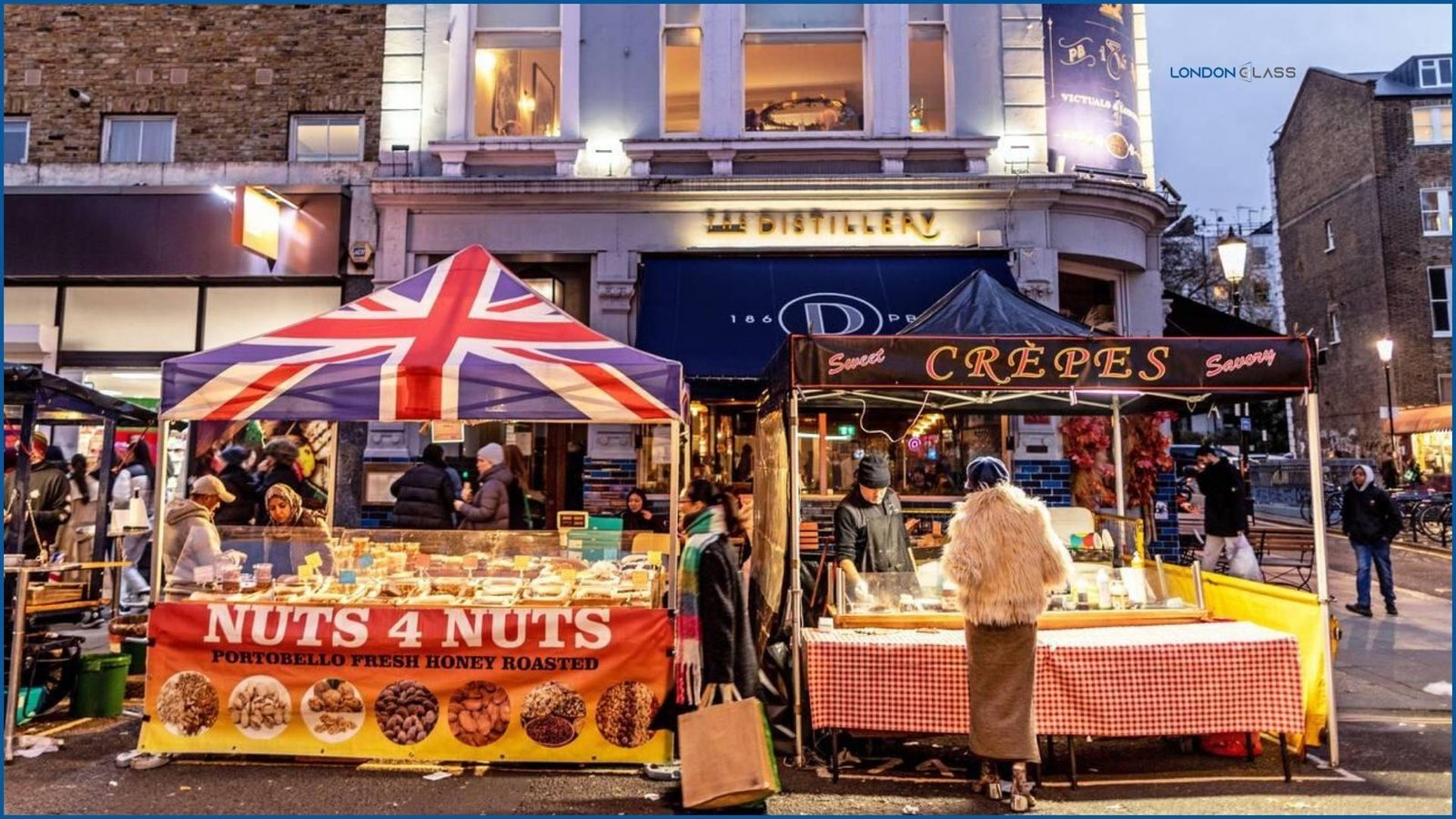 Street food stalls at Portobello Road Market in London offering nuts and crepes.