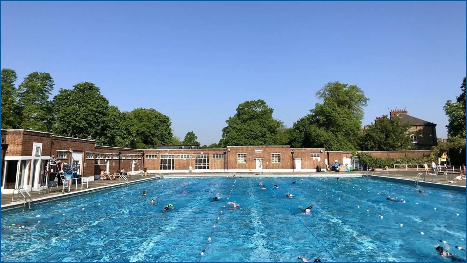 People swimming in Brockwell Park Lido on a sunny day