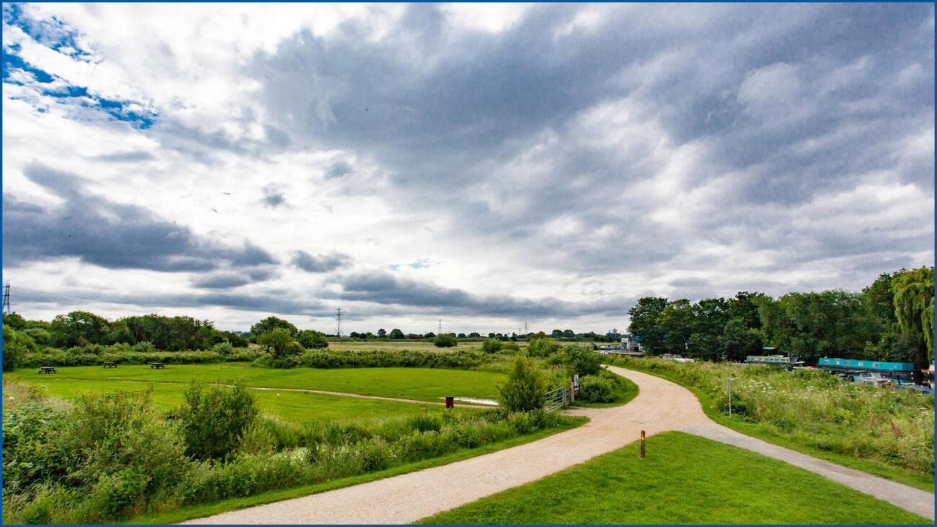 Open green field with walking path at Walthamstow Wetlands