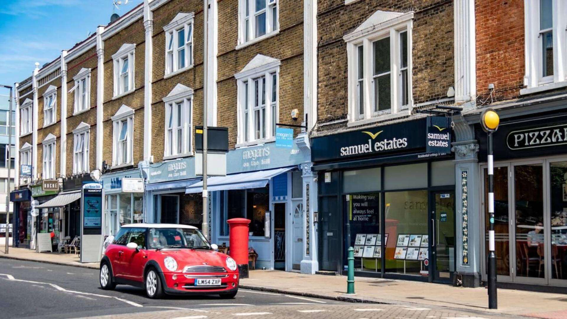 Bustling high street in Bedford Hill, featuring local shops, cafes, and residential buildings.