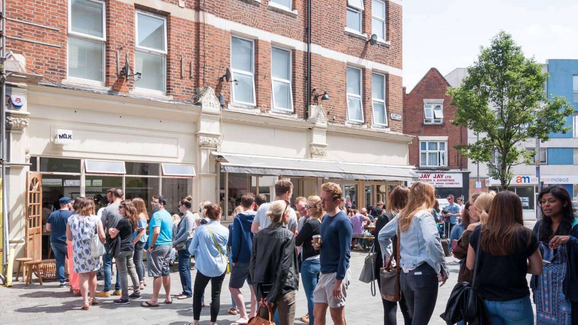 People gathered outside Milk cafe in Bedford Hill, Wandsworth, enjoying the vibrant atmosphere and popular brunch spot.