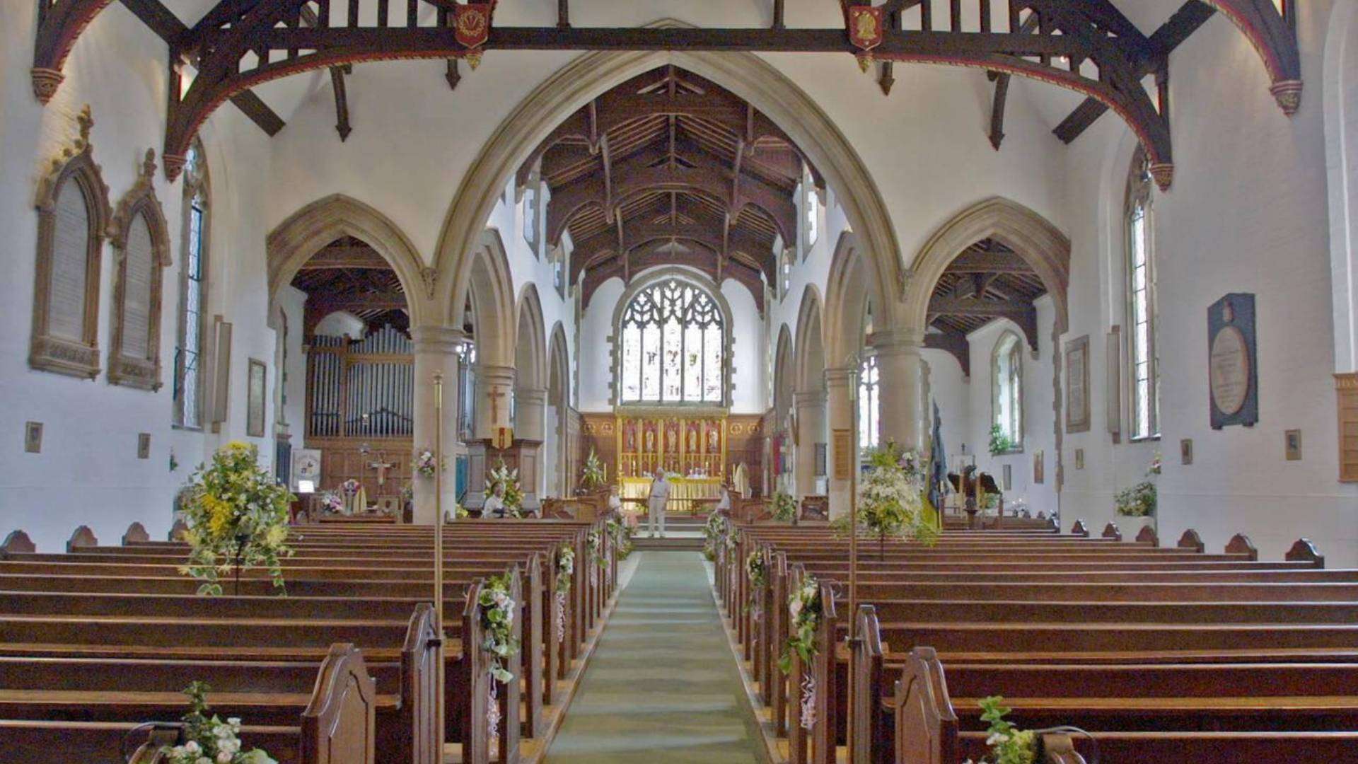 Interior of St Peter and St Paul Church, Chingford, with wooden pews and a grand altar