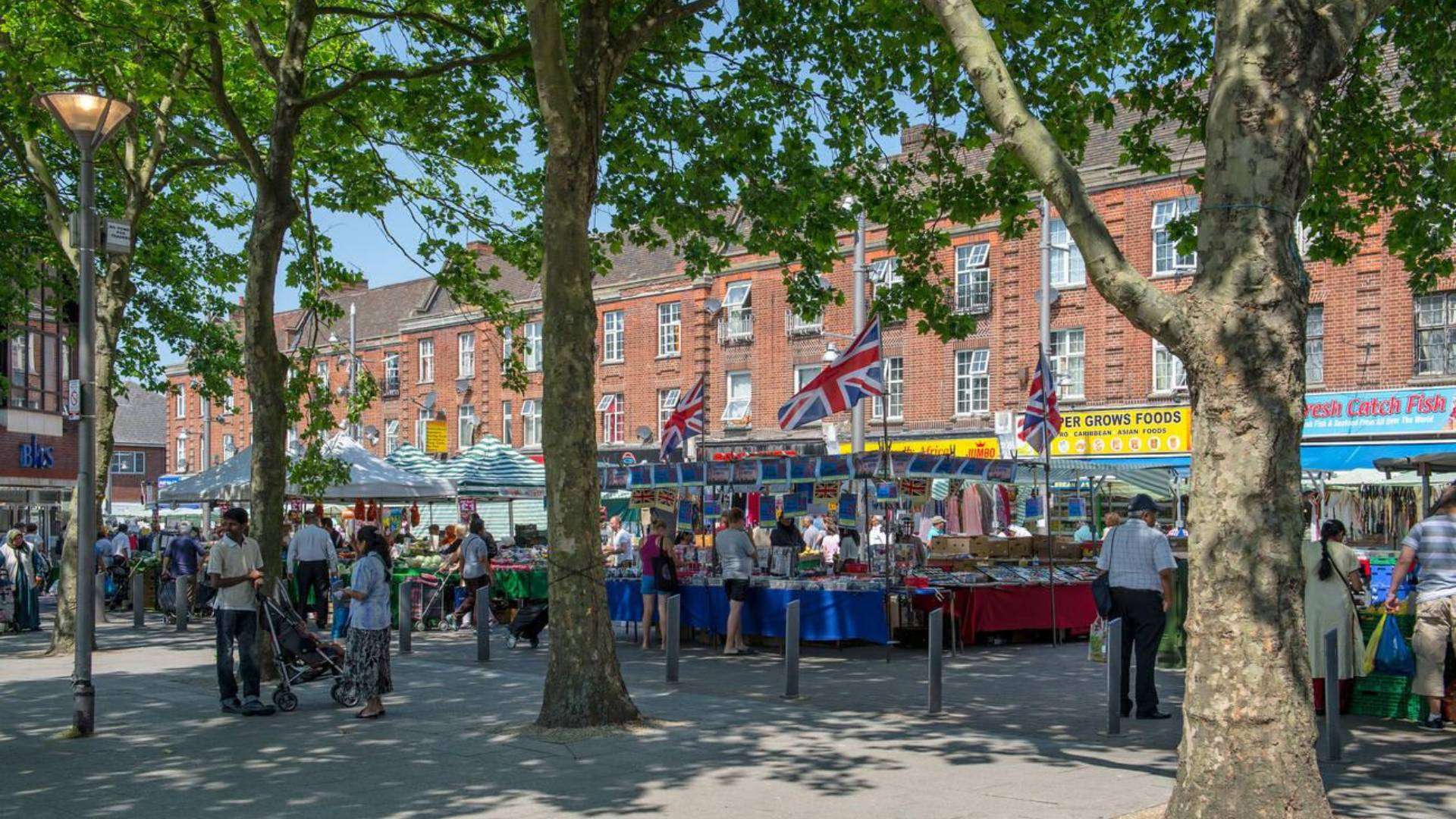 Walthamstow Market with outdoor stalls and shoppers on a sunny day