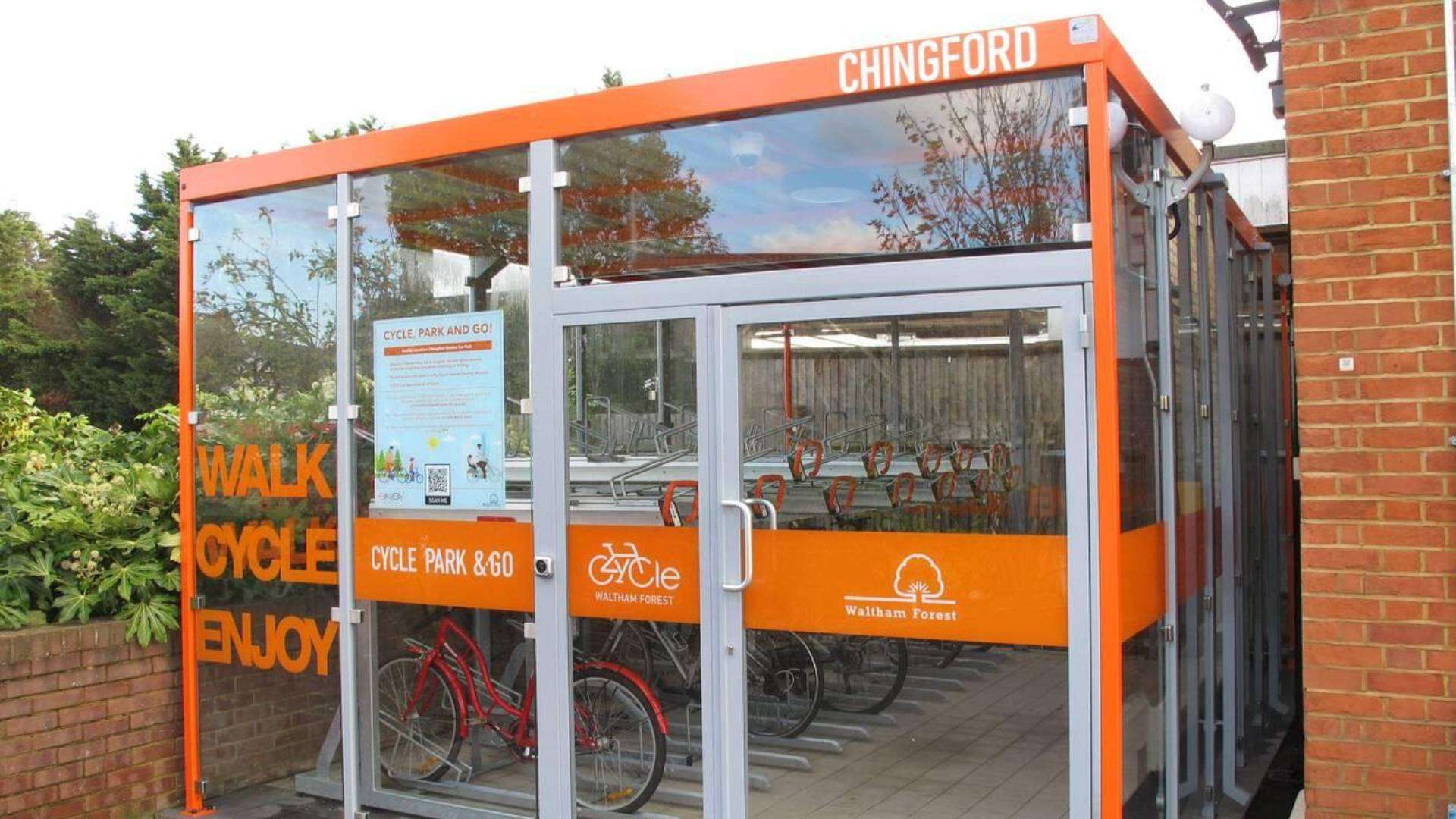 Modern cycle park beside Chingford Station with orange and glass design