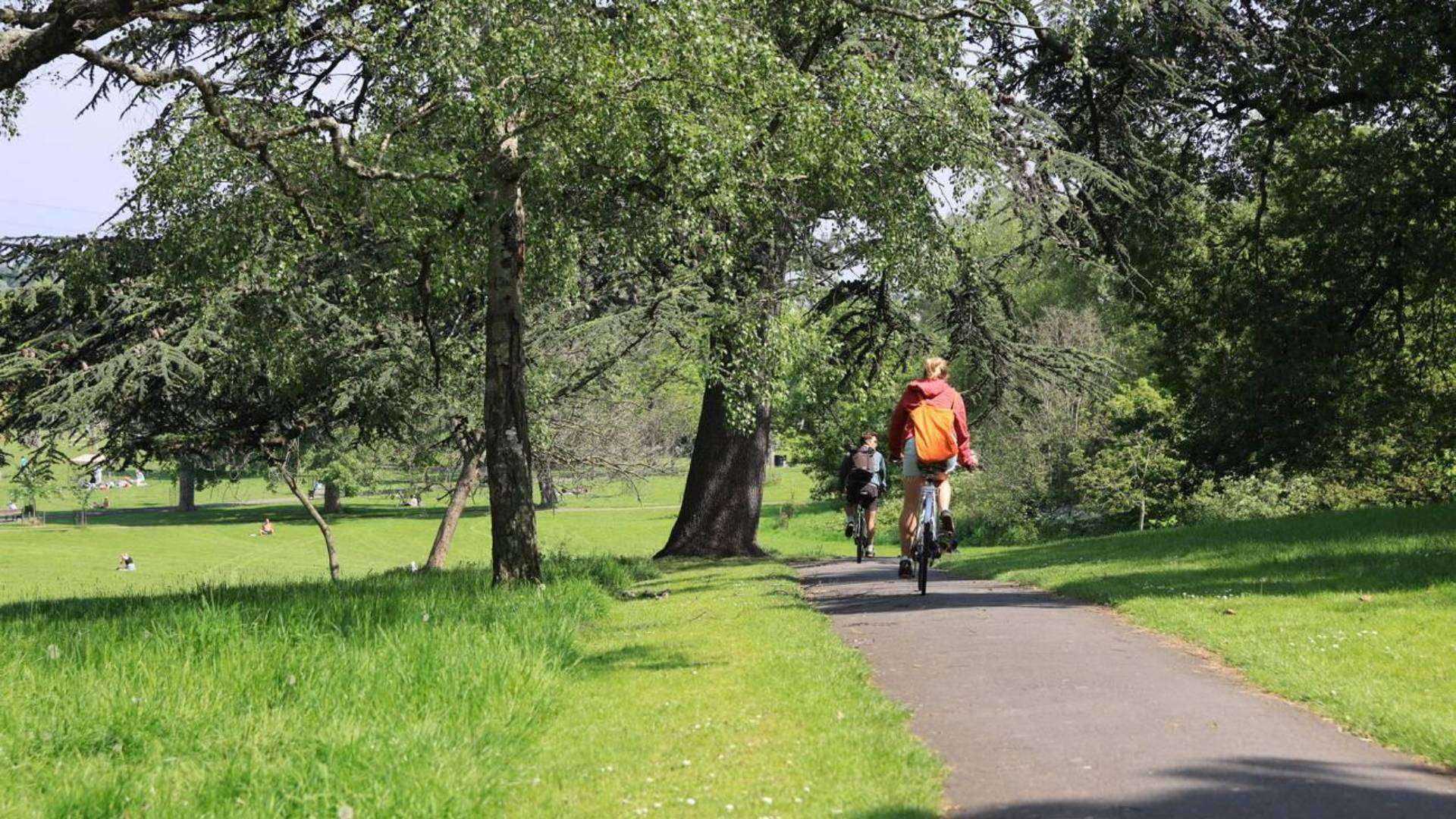 Cyclists enjoying a sunny ride along the green pathways in Hackney Marshes near Clapton Park.