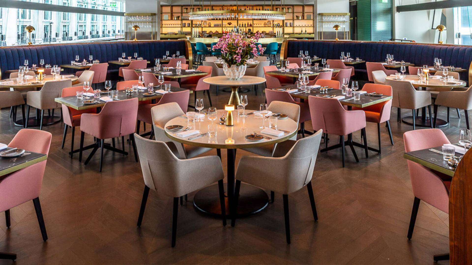 Elegant interior of a modern British restaurant with stylish seating and floral centerpiece.