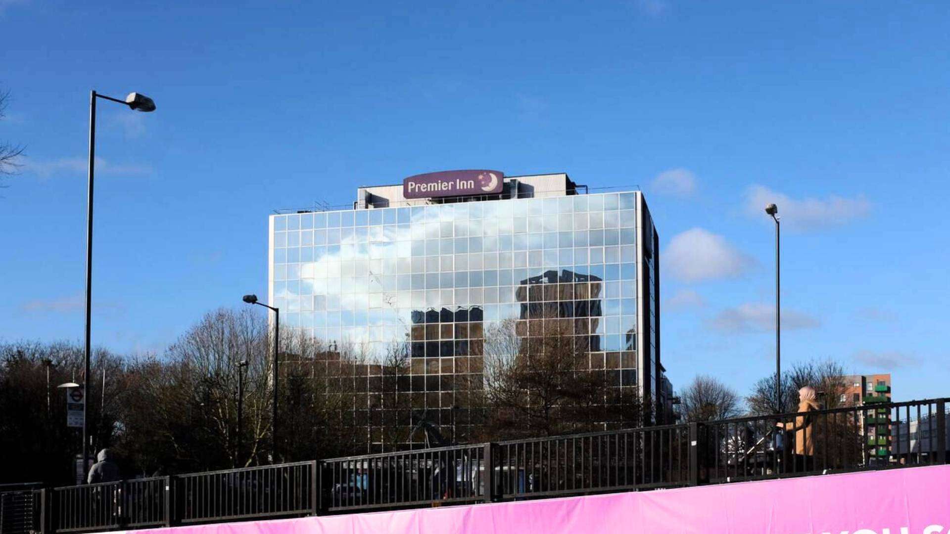 Glass-front Premier Inn Hotel reflecting the skyline in Sudbury London.